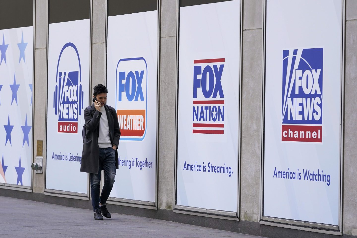 File &#8211; A man walks past the News Corp. and Fox News headquarters on Wednesday, April 19, 2023, in New York. Fox Corp.&#8217;s hefty $787.5 million settlement with Dominion over defamation charges is unlikely to make a dent in Fox&#8217;s operations, analysts say. (AP Photo/Mary Altaffer, File)
