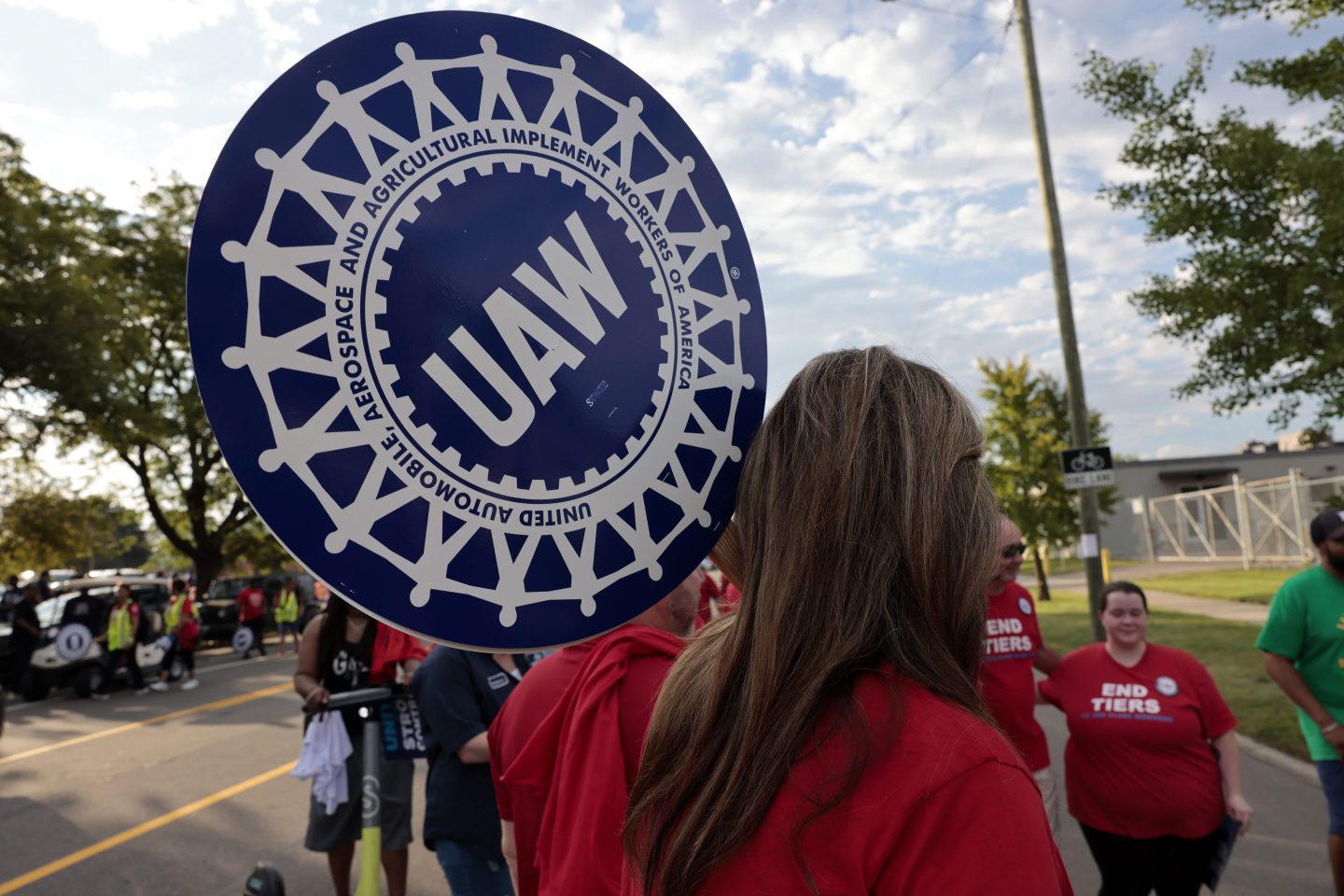 A United Auto Workers (UAW) supporter holds a sign during a Labor Day parade in Detroit, Michigan, US, on Monday, Sept. 4, 2023. The UAW&#8217;s 150,000 members are threatening a strike on General Motors, Ford Motor Co. and Stellantis NV, maker of the Jeep and Chrysler brands, if a deal with Detroit&#8217;s big three legacy carmakers is not reached by a September 14 deadline. Photographer: Jeff Kowalsky/Bloomberg via Getty Images