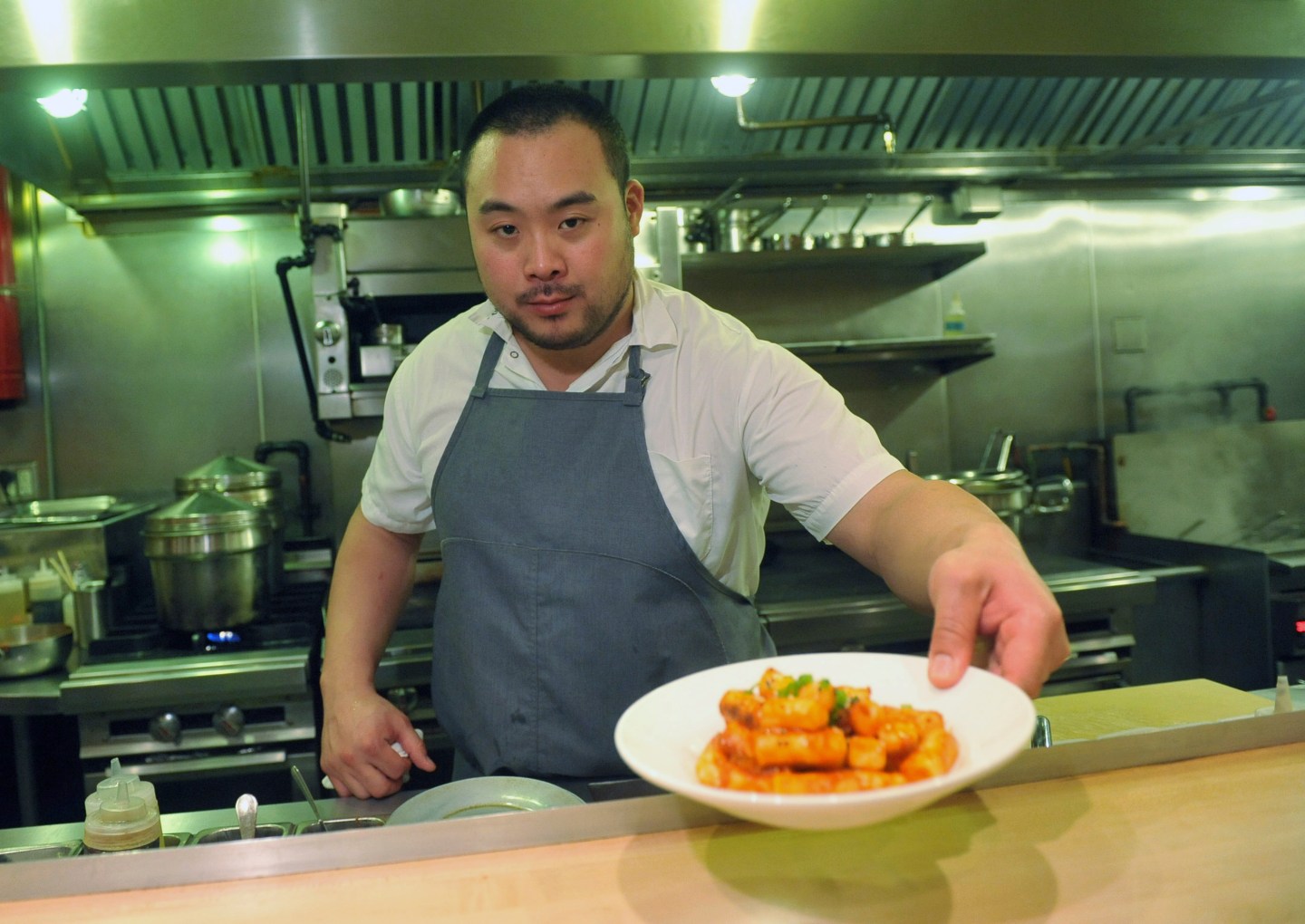 FILE &#8211; David Chang presents a dish at Momofuku Noodle Bar in New York on Thursday, Nov. 10, 2011. On Friday, April 12, 2024, Momofuku, a food and restaurant brand started by food mogul Chang, said it won&#8217;t defend its trademark on the name “chile crunch” after it sparked an outcry by sending cease-and-desist letters to other businesses using the term. (AP Photo/Diane Bondareff, File)