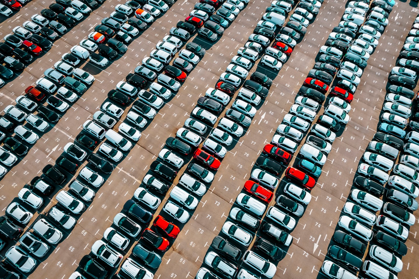 Aerial view of the stock of a large number of cars parked with order outside of an automobile company.