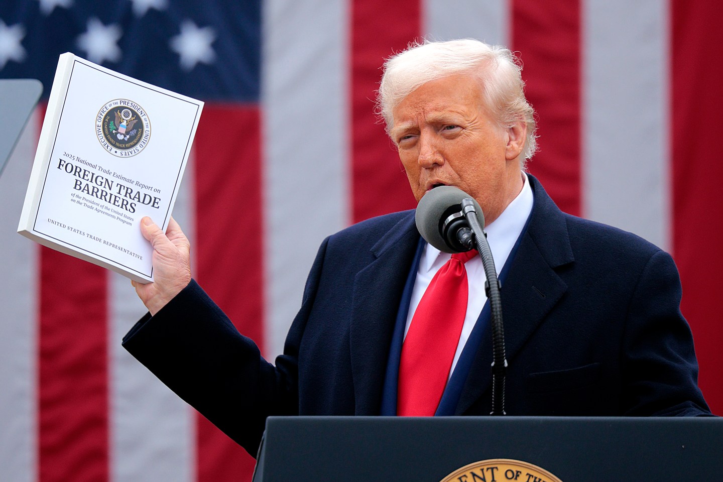WASHINGTON, DC &#8211; APRIL 02: U.S. President Donald Trump holds up a copy of a 2025 National Trade Estimate Report as he speaks during a “Make America Wealthy Again” trade announcement event in the Rose Garden at the White House on April 2, 2025 in Washington, DC. Touting the event as “Liberation Day”, Trump is expected to announce additional tariffs targeting goods imported to the U.S. (Photo by Chip Somodevilla/Getty Images)