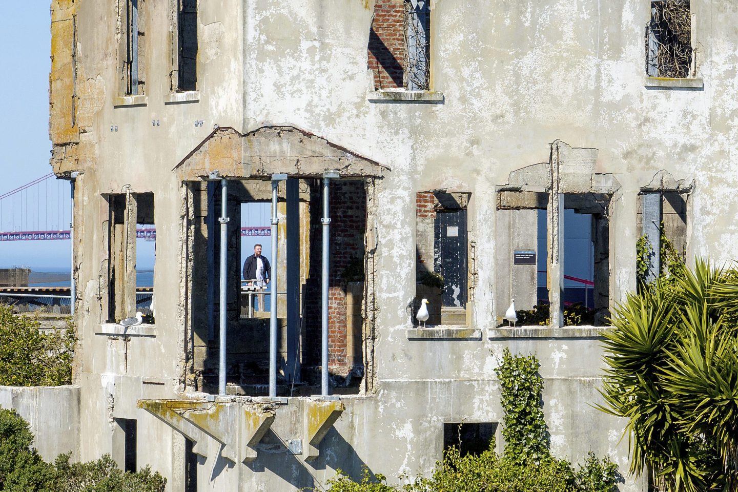 A visitor looks at the warden&#8217;s house at Alcatraz Island on Monday, May 5, 2025, in San Francisco. (AP Photo/Noah Berger)