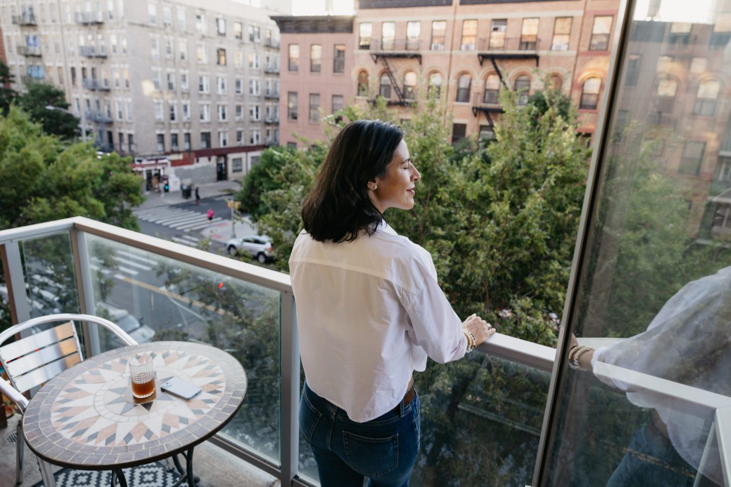 woman looking out window in NYC apartment