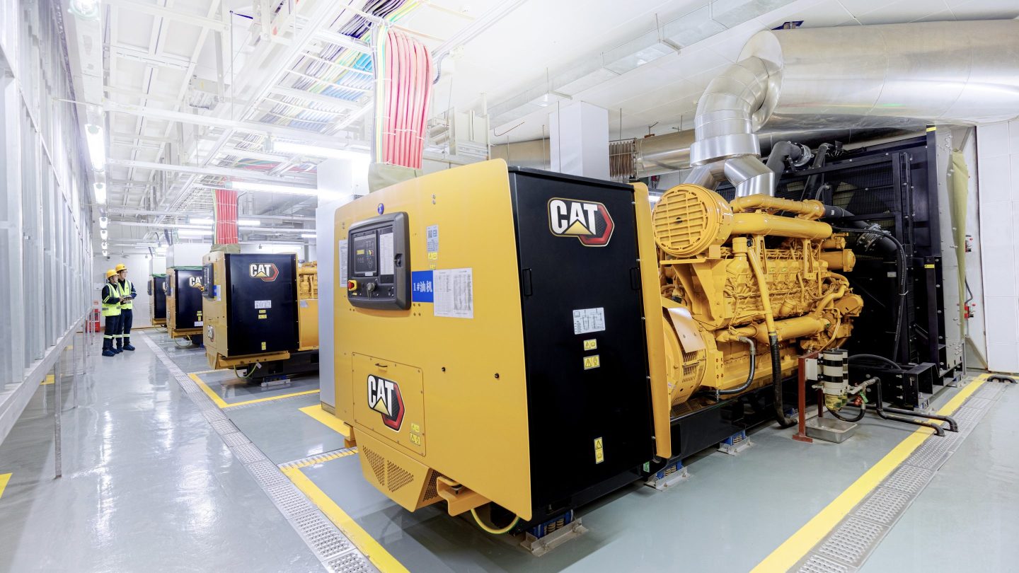 Caterpillar power generators are shown in a row at a data center facility. The generators can be used for primary or backup power.